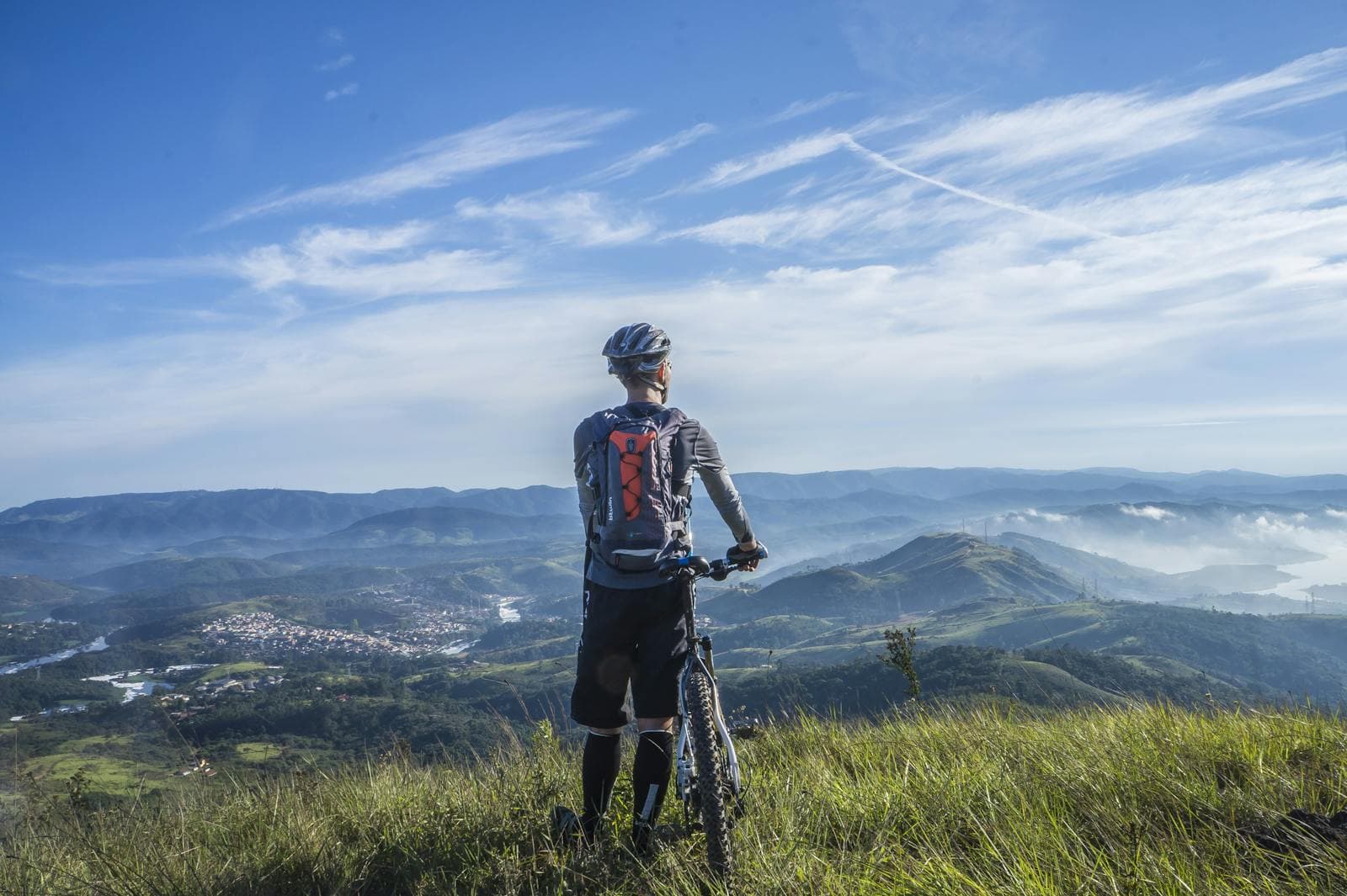 Mountain biker overlooking a valley at sunset